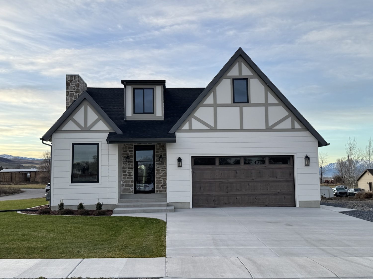 The Lucy, a Tudor-inspired home with a stone entry and two-car garage, front exterior, 2025 Top of Utah Parade of Homes